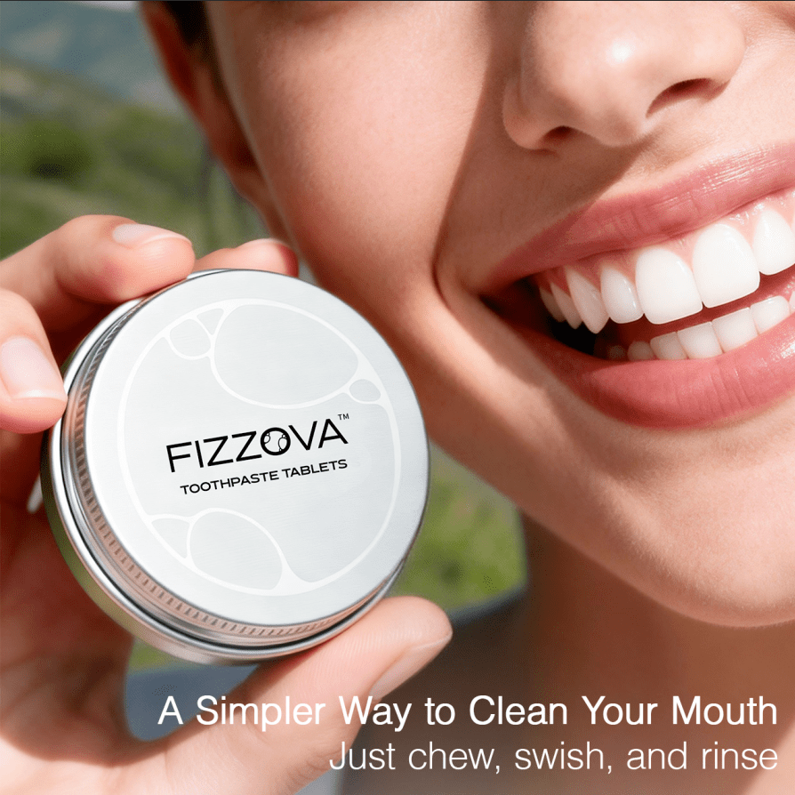 Woman smiling holding FIZZOVA zero waste toothpaste tablets. For naturally white teeth.